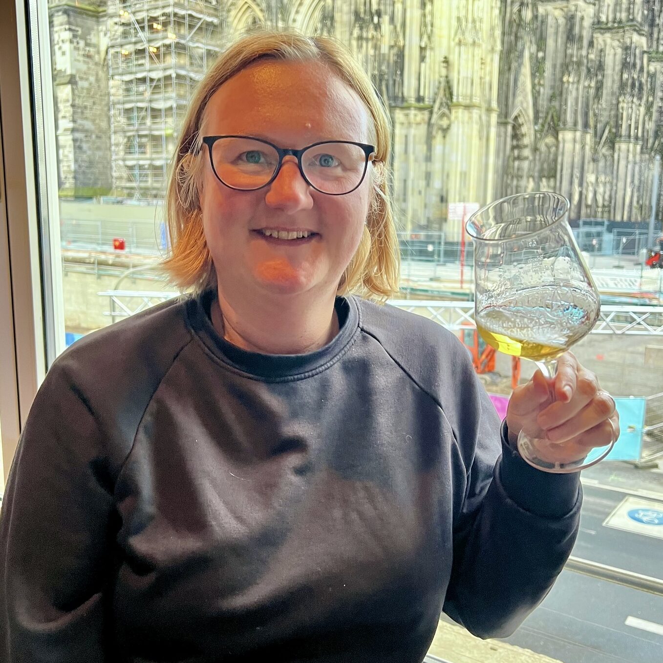 Biersommeliere Jessica Morgner am Strand mit einer Flasche alkoholfreiem Bier